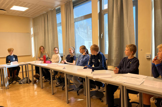 en gruppe mennesker som sitter ved bord