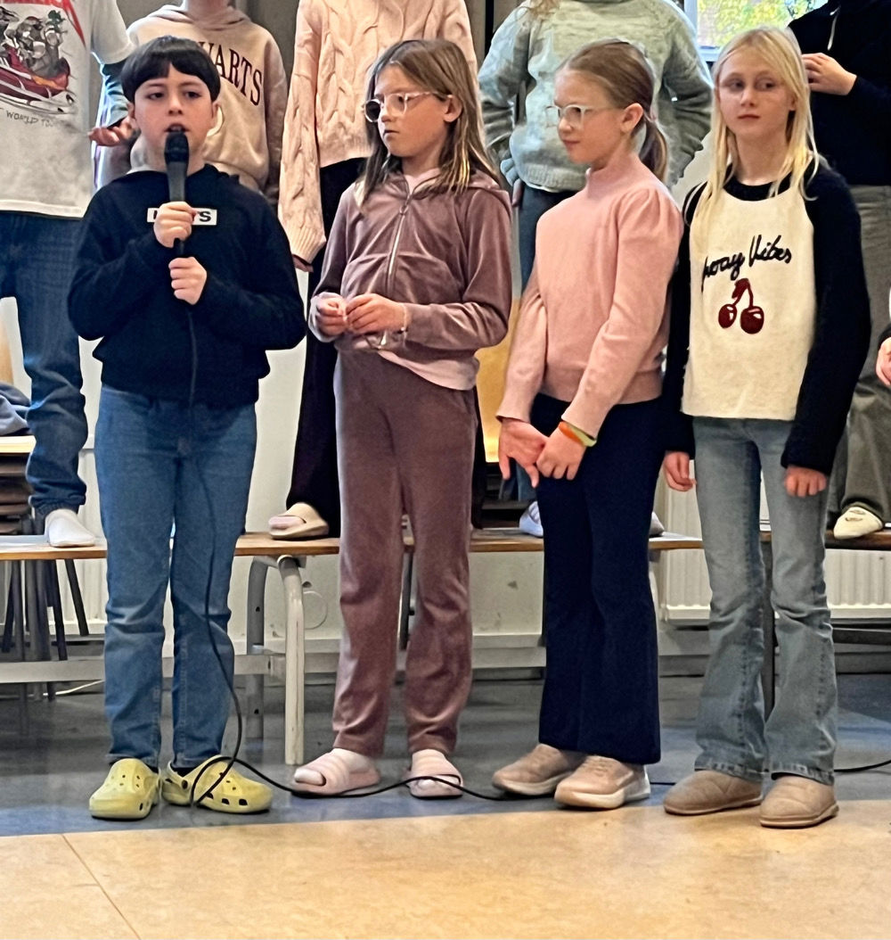 en gruppe mennesker som står på en scene og holder en mikrofon