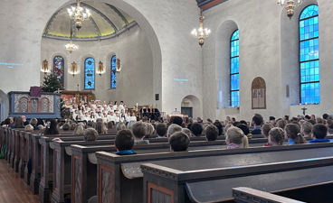 en gruppe mennesker som sitter i en kirke