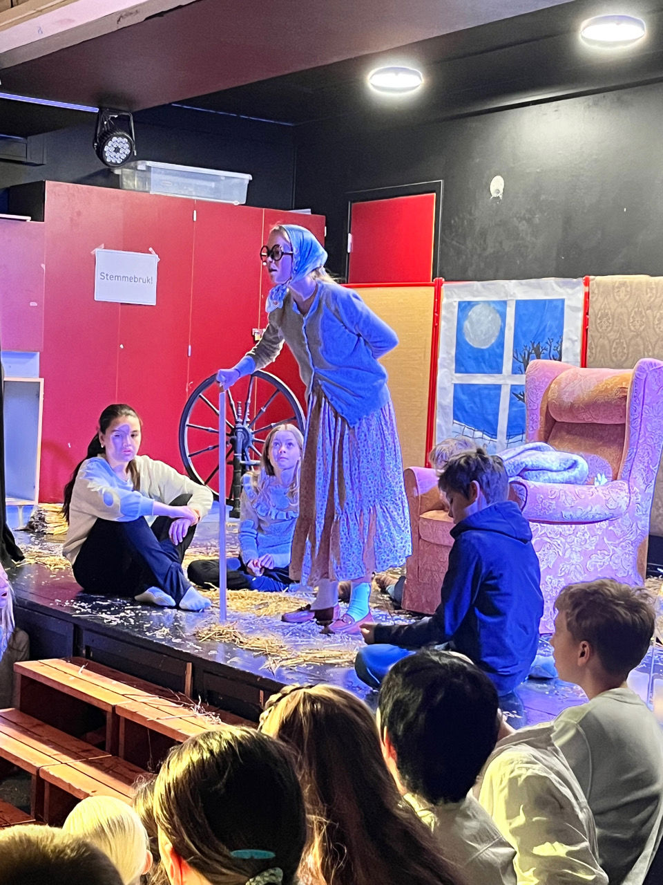 en person i et plagg som står foran en gruppe mennesker