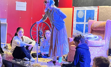 en person i et plagg som står foran en gruppe mennesker