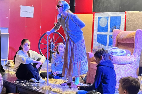 en person i et plagg som står foran en gruppe mennesker