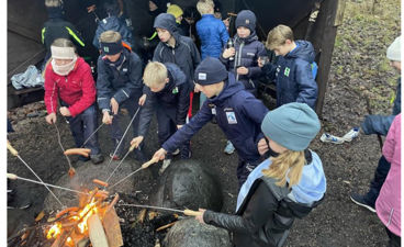 en gruppe mennesker rundt et leirbål