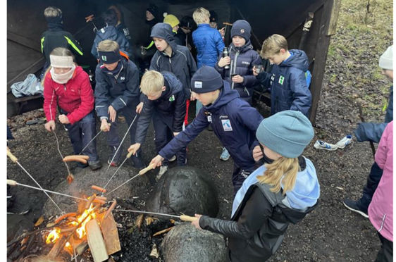 en gruppe mennesker rundt et leirbål
