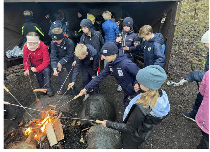 en gruppe mennesker rundt et leirbål