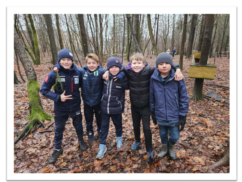 En gruppe mennesker poserer for et bilde i skogen