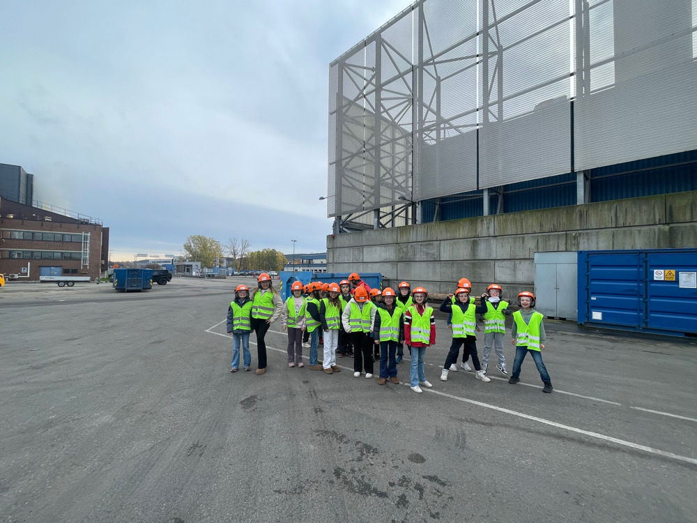 En gruppe mennesker i vernevester som står på en vei